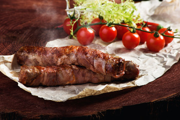 Fried sausages with sauces and herbs on a wooden serving Board. Great beer snack on a dark background. Top view with copy space