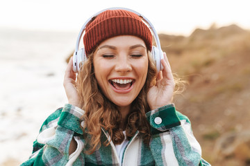 Image of woman listening to music with headphones while walking outdoors