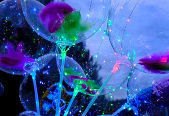 Defocused image of neon lights of illuminated balloons filled with hellium with led light at night