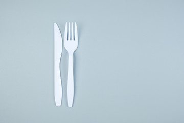 White plastic fork and knife on gray background with Copy space for text. Environmental Protection, Zero waste, Reusable, Say No Plastic, World Environment day and Earth day concept