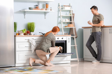 Happy couple cooking together in kitchen