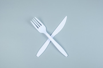 White plastic fork and knife on gray background with Copy space for text. Environmental Protection, Zero waste, Reusable, Say No Plastic, World Environment day and Earth day concept