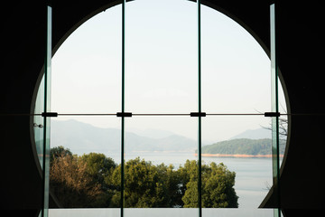 Beautiful lake view through the chinese arch wall and glass window