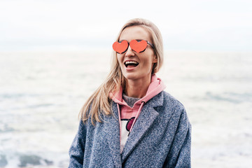 Funny woman in lovely sunglasses laughting and Valentine's Day celebrating. Emotions of joy and happiness.