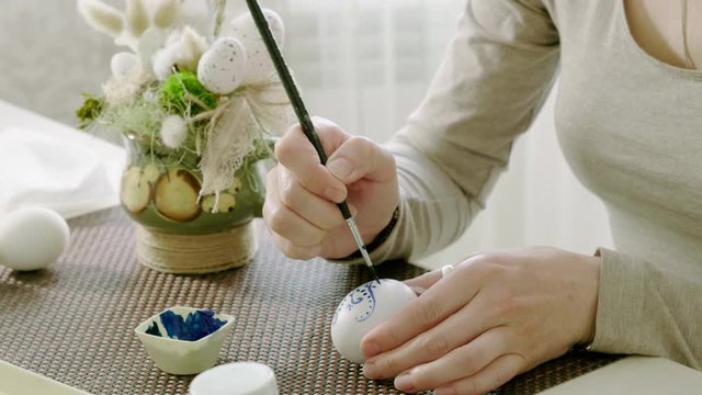 Close-up of woman painting chicken eggs for Easter holiday. 4K