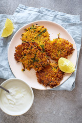  Flatlay with potato latkes with lemon and yoghurt. Traditional israeli festive cuisine.