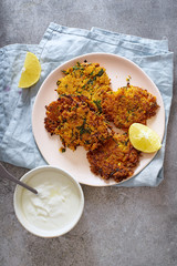  Flatlay with potato latkes with lemon and yoghurt. Traditional israeli festive cuisine.