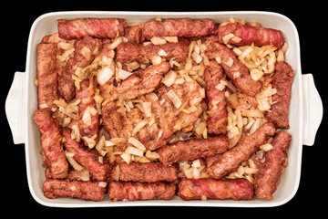 Barbecued Meat Loaves and Chicken Thighs Served with Minced Onion in Casserole Dish Isolated on Black Background