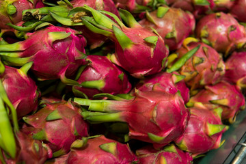 Dragon fruit with a lots of dragon fruit on a background. Dragon fruit or pitaya. Tropical and exotic fruits. Healthy and vitamin food concept.