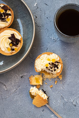 homemade shortbread tartlets or cupcakes with delicate cream and orange jam, decorated with chocolate chips. natural sweets concept. cozy tea party