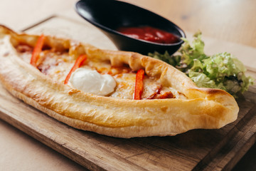 close up calzone pizza on wooden board
