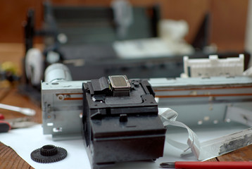 Printer disassembled into parts. Repair of the printer. Print head of the printer close-up.