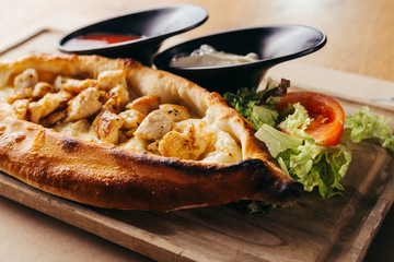 close up calzone pizza on wooden board