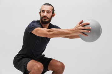 Image of sportsman wearing tracksuit doing workout with fitness ball