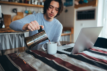 teenage student drinking morning coffee at home in kitchen