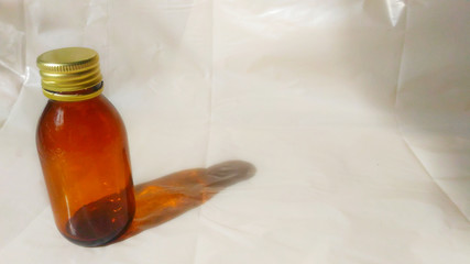 On the left is an empty brown glass bottle of 100 ml from tincture, medicine or pills. Yellow metal...
