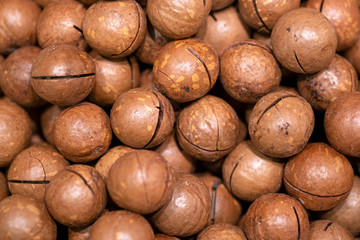 Organic macadamia nuts in brown shell selling at local market. Healthy and tasty snack and pastry...