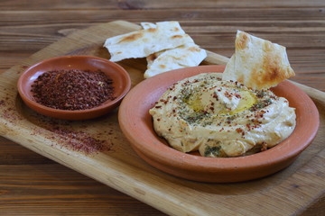 Hummus and pita on a wooden table