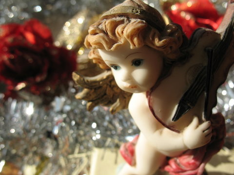 Angioletto con violino e decorazioni natalizie argentate e rose rosse decorative