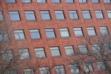 Red brick classic industrial building facade with multiple windows