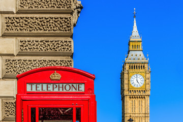 Red telephone box with Big Ben against blue sky in the background