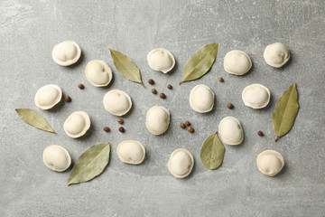Raw dumplings and spices on grey background, space for text