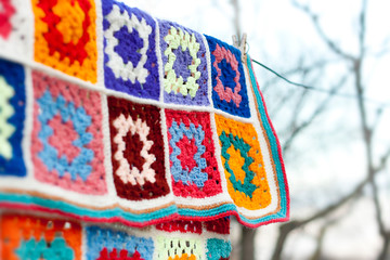Colorfull handmade crochet blanket afgan made from woolen granny squares hanging outdoors