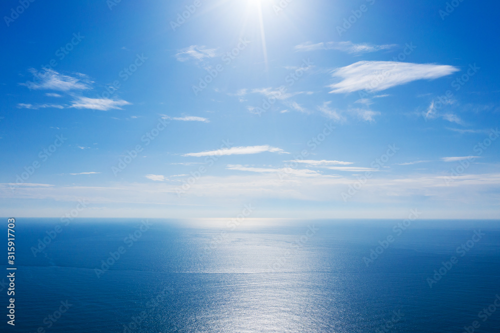 Wall mural blue sea or ocean with sunny and cloudy sky