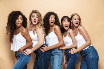Image of multinational women expressing surprise and looking aside