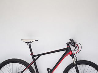 Fototapeta na wymiar Crop image. Cross country mountain bike at home, white wall background. Copy space.