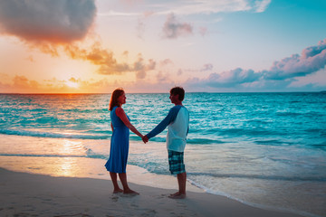 romantic loving couple holding hands at sunset beach