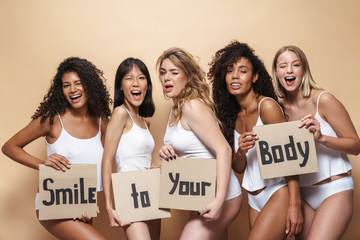 Image of pleased multinational women posing with placards and winking