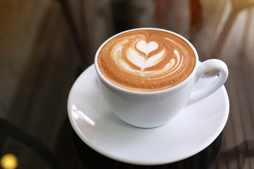 Heißer Latte-Kaffee im Café-Restaurant auf den Tisch gestellt, morgens Frühstück trinken
