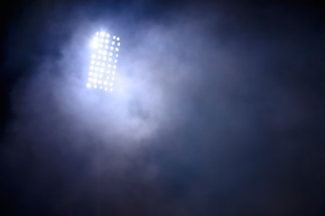 stadium lights and smoke against dark night sky background