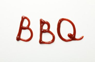 Inscription BBQ made of sauce on white background, top view