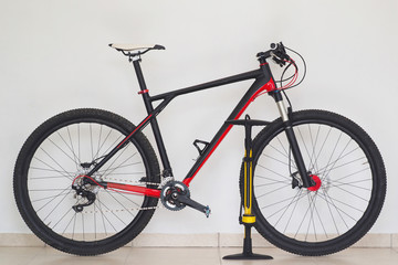 Lifestyles. Cross country mountain bike at home with yellow pump, white wall background.