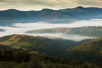Mountain landscape, green valley. Clouds floating over the tops of the mountains in the French...