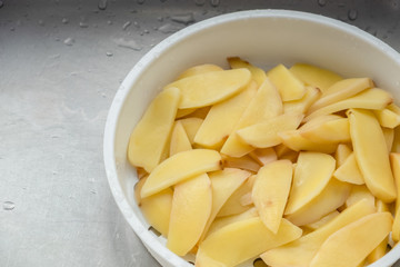 Boiled potatoes cut into beautiful pieces, placed in a cup for cooking.