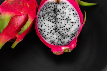 Dragon fruit. Vibrant Dragon Fruit on black background. Sliced white dragon fruit or pitaya on...