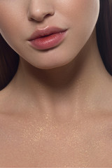 Cosmetics, makeup and trends. Bright lip gloss and lipstick on lips. Closeup of beautiful female mouth with natural lip makeup. Beautiful part of female face. Perfect clean skin in red light © evgeniyasht19