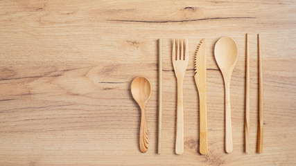 Bamboo utensils cutlery set. Reusable cutlery travel set. Eco-friendly wooden silverware on wooden table. Flat lay, top view. Zero waste, plastic free concept. Sustainable lifestyle