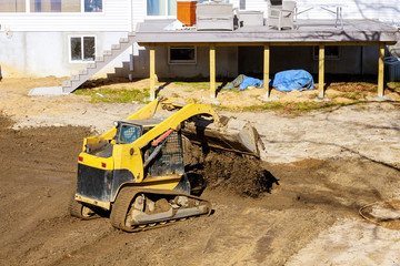 Mini bulldozer with earth doing landscaping works