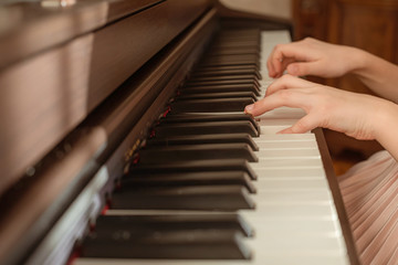 Fototapeta na wymiar Girls hands playing the piano. Selective focus.