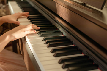 Girls hands playing the piano. Selective focus.