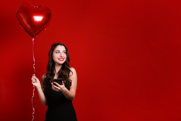 Portrait of young brunette woman posing with helium inflated air balloon. Happy valentine's day...