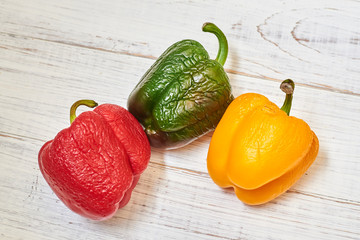 Three multi-colored bell peppers old and beginner go bad. Substandard vegetables, improper storage.