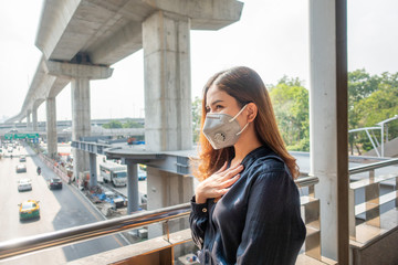 Beautiful woman wearing anti dust mask protect air pollution and pm 2.5 on street city