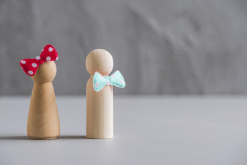 The man turned away from the woman during quarrel. Wooden people man and woman against the background of a gray concrete wall. The concept of family, friendship, relationships