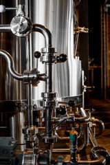 Large reservoirs, tanks and pipes with manometers in private microbrewery. Craft beer production line. Industrial interior background.  View from above.