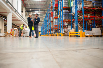 Obraz premium Managers in Warehouse discuss about business strategy